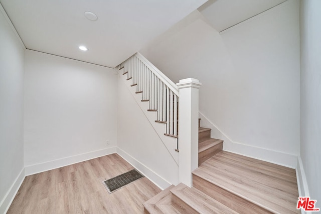 staircase with hardwood / wood-style floors