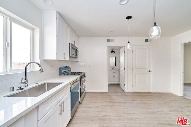 kitchen featuring light wood-type flooring, stainless steel appliances, white cabinetry, and sink