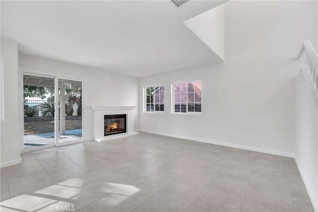 unfurnished living room featuring light tile patterned floors and a brick fireplace