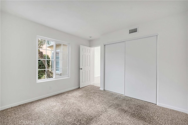 unfurnished bedroom featuring carpet floors and a closet