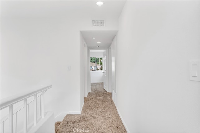 hallway featuring light colored carpet