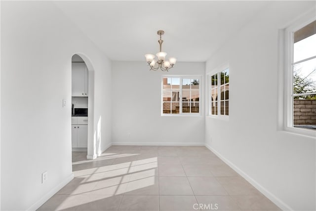 unfurnished dining area with light tile patterned flooring and an inviting chandelier