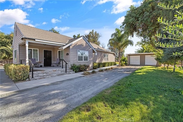 view of front facade with a porch, a garage, an outdoor structure, and a front yard