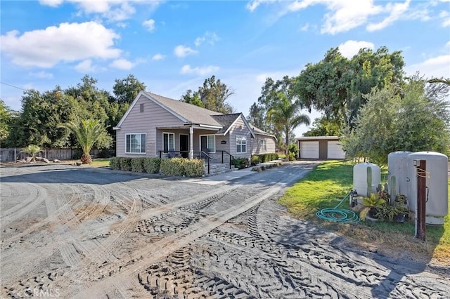 view of front of home with a porch, a garage, and an outdoor structure