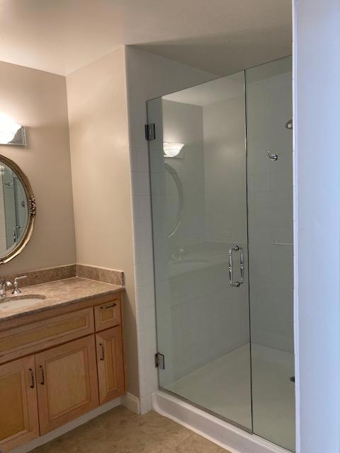 bathroom with tile patterned floors, a shower with shower door, and vanity