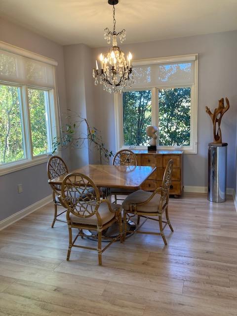 dining area with an inviting chandelier and light hardwood / wood-style floors