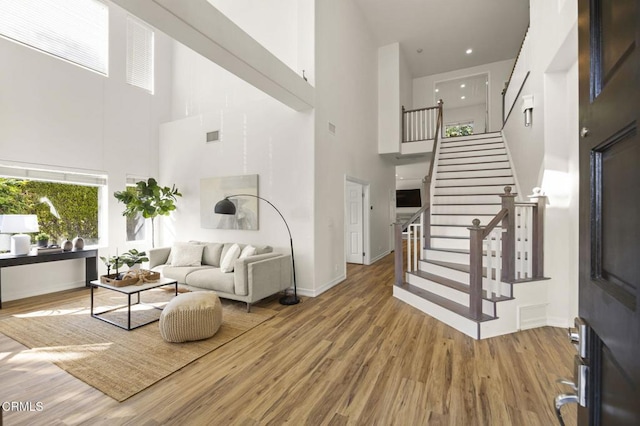 living room with hardwood / wood-style flooring and a high ceiling