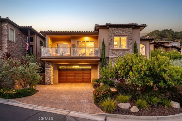 mediterranean / spanish home featuring a balcony and a garage