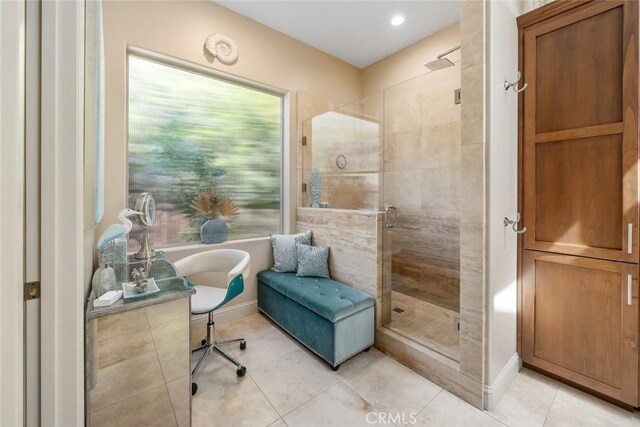 full bath featuring a shower stall, a freestanding tub, tile patterned floors, and baseboards