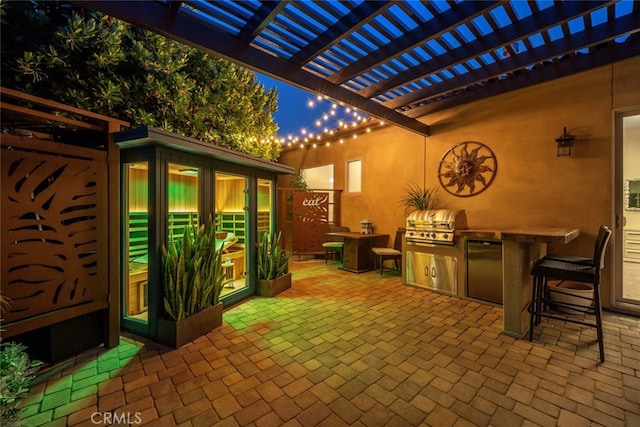 view of patio / terrace with a pergola, an outdoor kitchen, and a grill