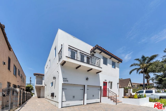 mediterranean / spanish home featuring a balcony and a garage