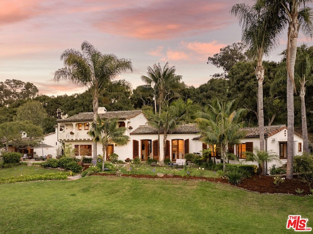 mediterranean / spanish house featuring a lawn