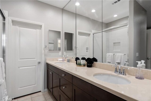 bathroom with an enclosed shower, tile patterned flooring, and vanity