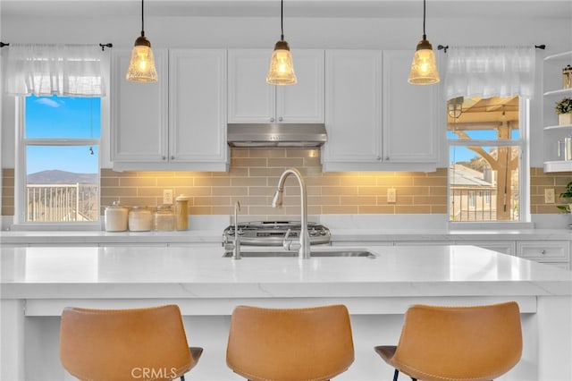 kitchen featuring a kitchen breakfast bar, white cabinets, and tasteful backsplash