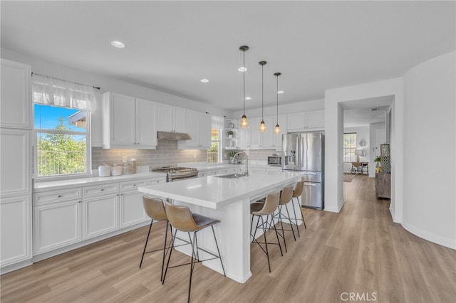 kitchen featuring stainless steel appliances, white cabinets, light hardwood / wood-style floors, and sink