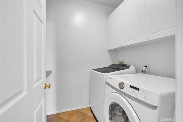 laundry area featuring cabinets, light tile patterned floors, and separate washer and dryer