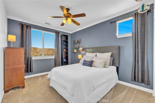 bedroom with crown molding, light carpet, and ceiling fan