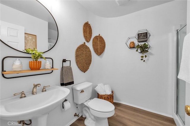 bathroom with a shower with shower door, sink, hardwood / wood-style floors, and toilet