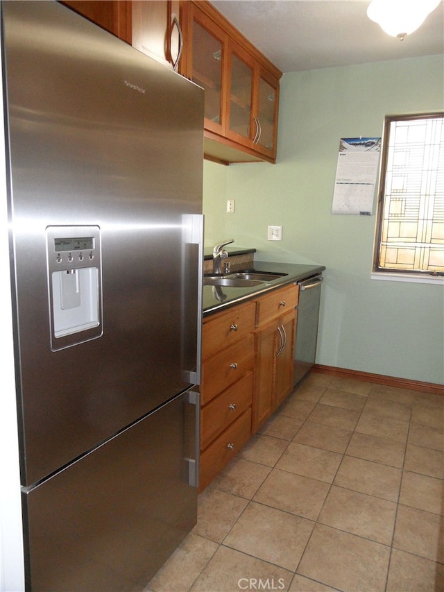 kitchen with light tile patterned flooring, appliances with stainless steel finishes, and sink