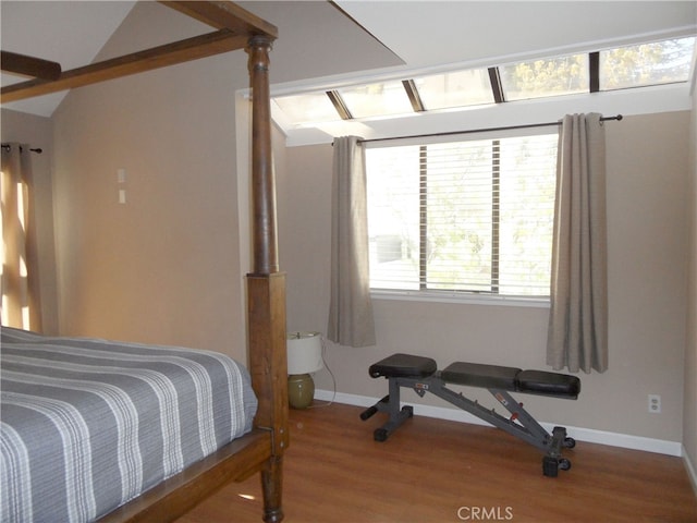 bedroom with vaulted ceiling and hardwood / wood-style floors