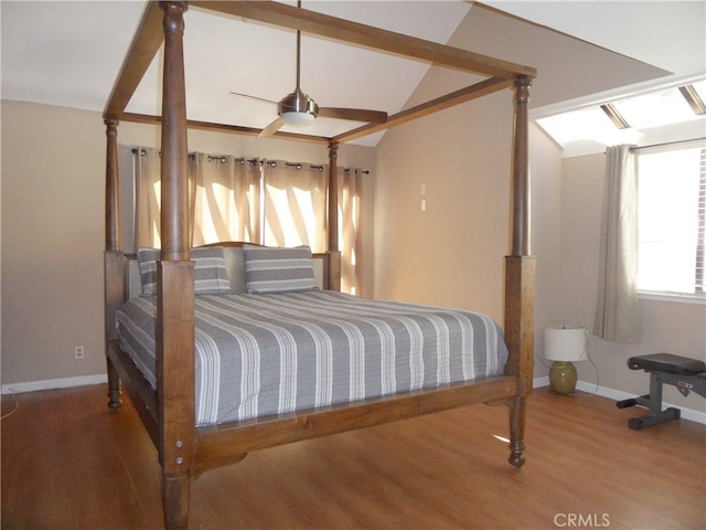 bedroom with ceiling fan, vaulted ceiling, and hardwood / wood-style floors