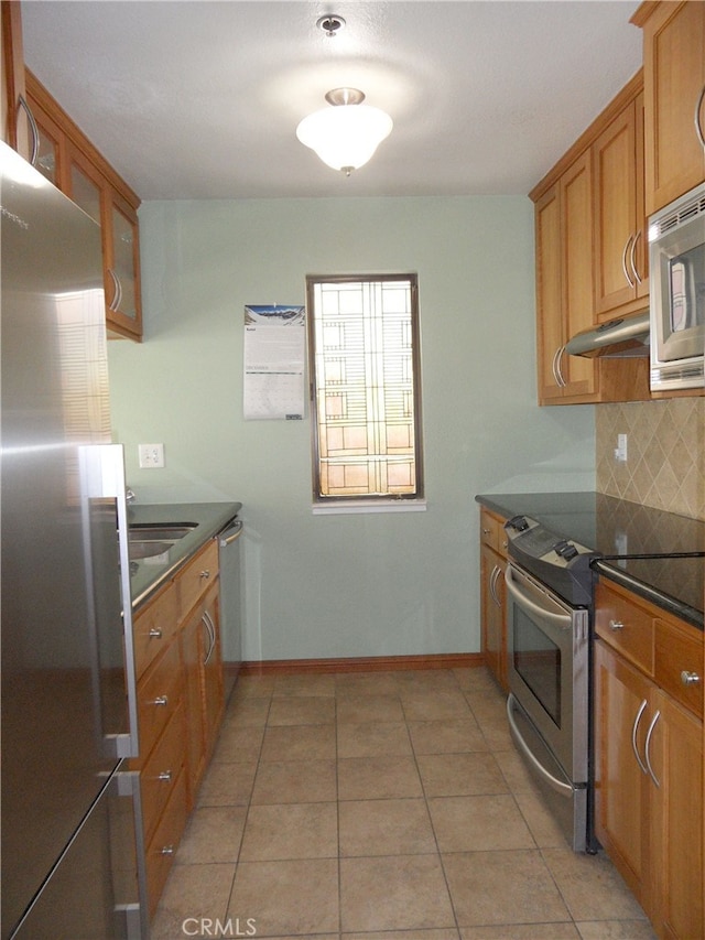 kitchen featuring sink, appliances with stainless steel finishes, light tile patterned floors, and tasteful backsplash