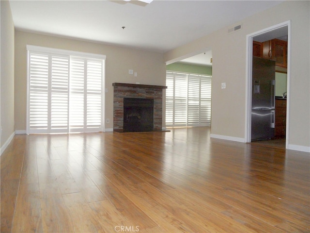 unfurnished living room featuring hardwood / wood-style flooring and a healthy amount of sunlight