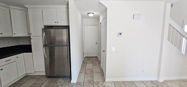 kitchen featuring white cabinets and stainless steel refrigerator