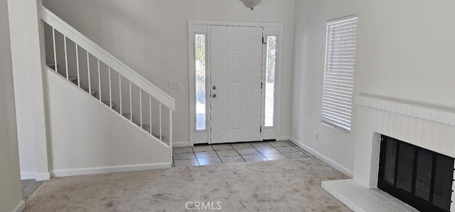 tiled foyer featuring a fireplace