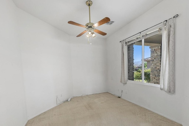 spare room featuring light carpet and ceiling fan