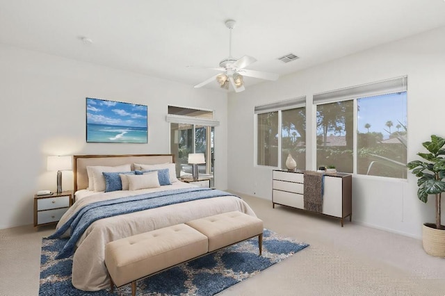 carpeted bedroom featuring multiple windows and ceiling fan