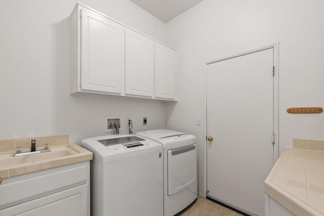 laundry area featuring cabinets, sink, and washer and dryer