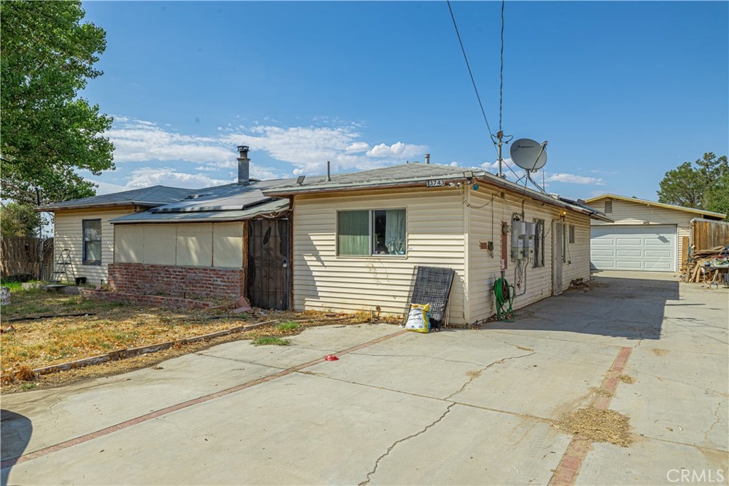 rear view of property featuring an outbuilding and a garage