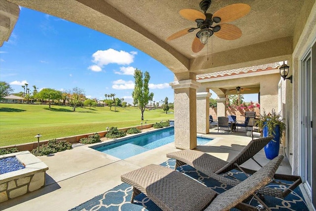 view of pool with a lawn, a patio area, and ceiling fan