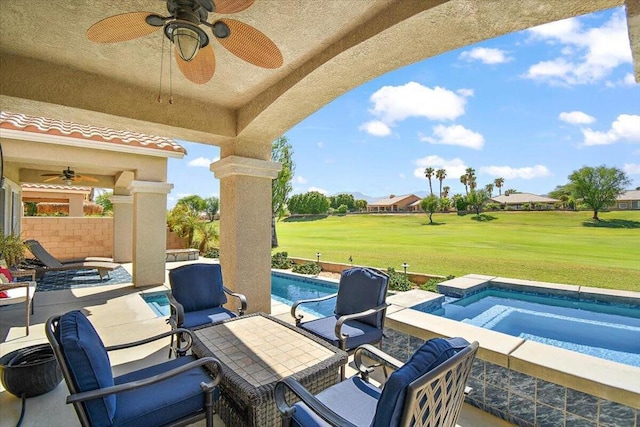 view of patio featuring ceiling fan and a pool with hot tub