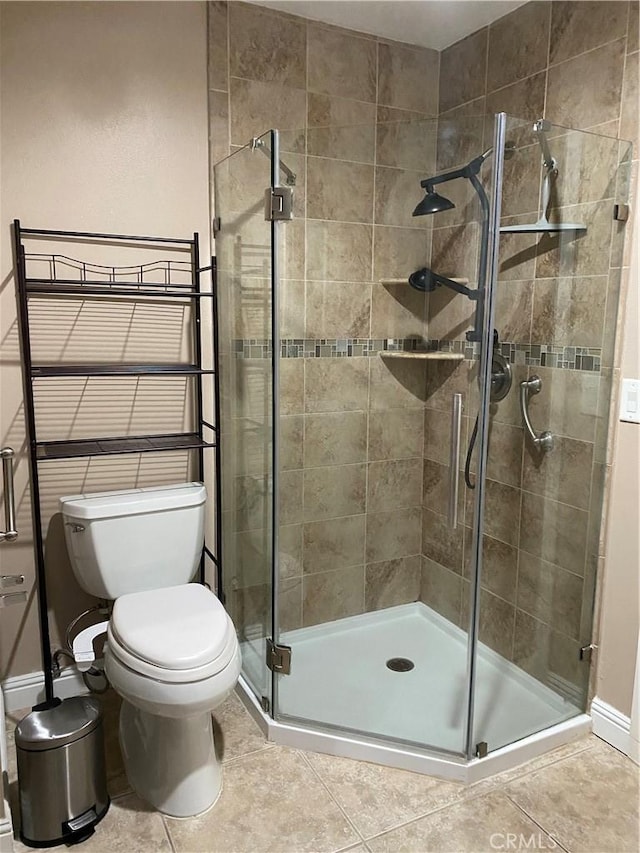 bathroom with tile patterned floors, toilet, and an enclosed shower