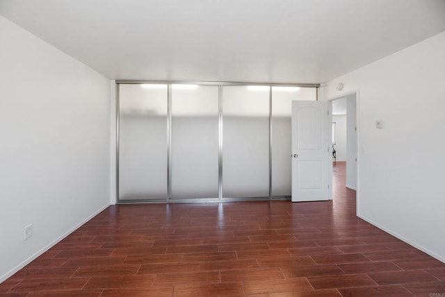 unfurnished bedroom featuring a closet and dark hardwood / wood-style flooring