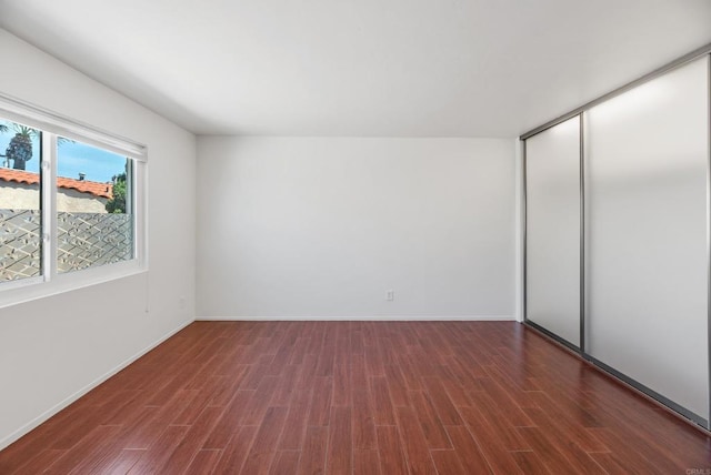 unfurnished bedroom featuring dark hardwood / wood-style flooring and a closet