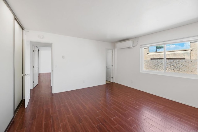 unfurnished room featuring dark hardwood / wood-style floors and an AC wall unit