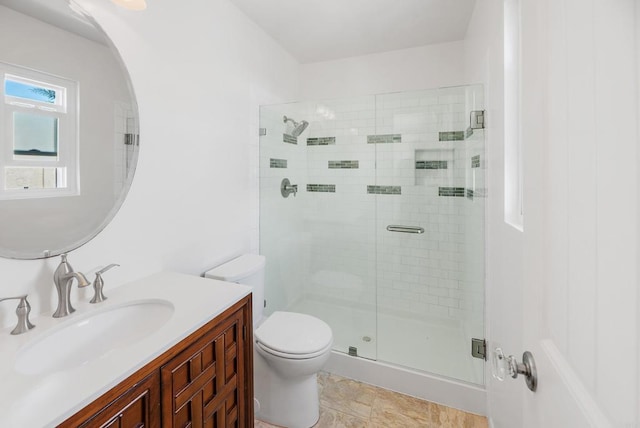 bathroom with vanity, toilet, and a shower with door