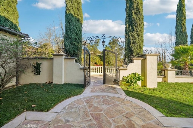 view of gate with a lawn