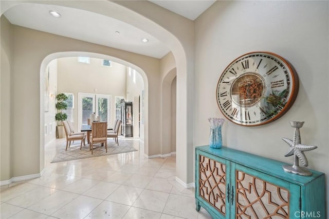 corridor with light tile patterned floors and french doors