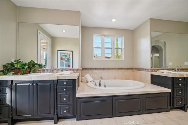 bathroom featuring a tub to relax in, vanity, and tile patterned flooring