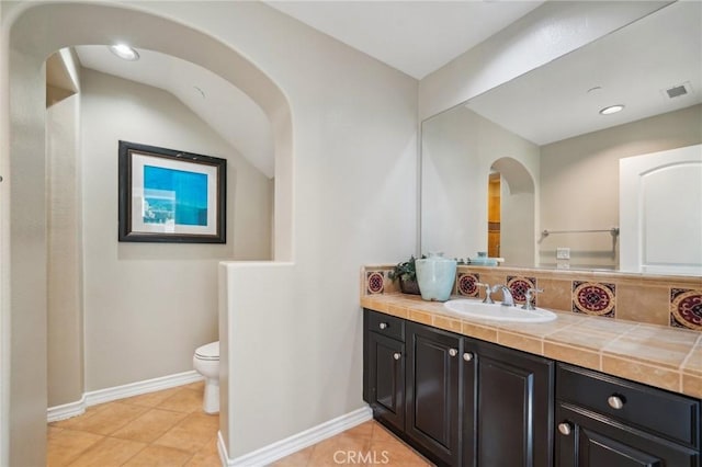 bathroom with toilet, tile patterned floors, and vanity