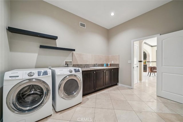 laundry area featuring cabinets, sink, washer and clothes dryer, and light tile patterned floors