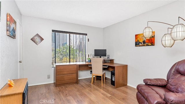 office space featuring a textured ceiling and light hardwood / wood-style flooring