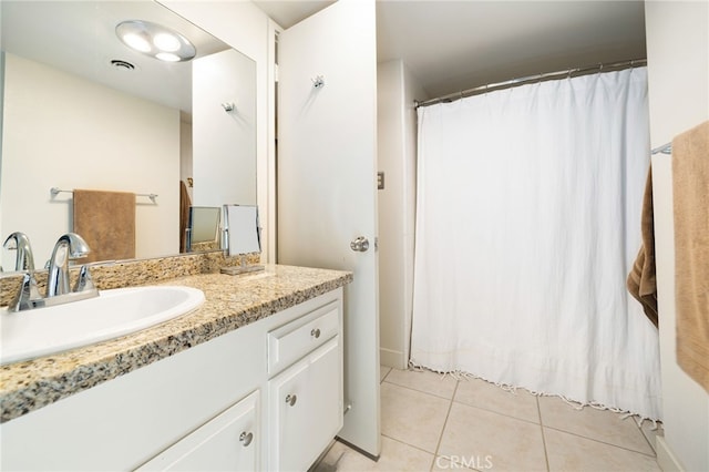 bathroom featuring walk in shower, vanity, and tile patterned floors