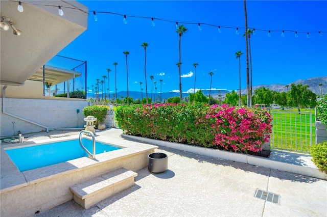 view of swimming pool with a mountain view and a patio