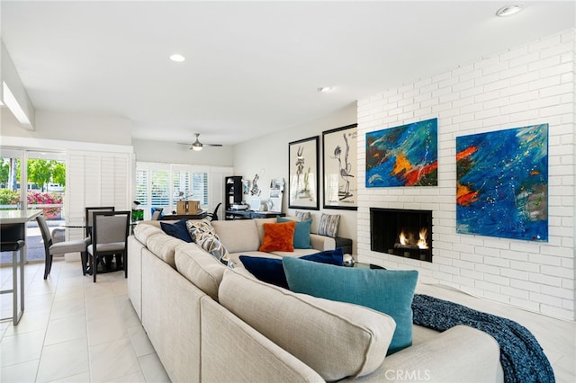 tiled living room with a brick fireplace and ceiling fan