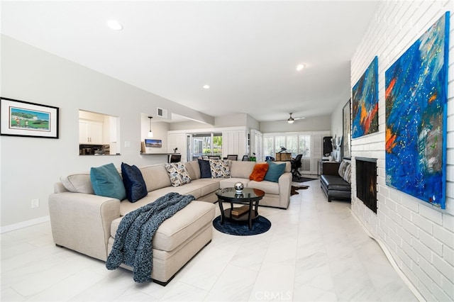 living room featuring a large fireplace and ceiling fan